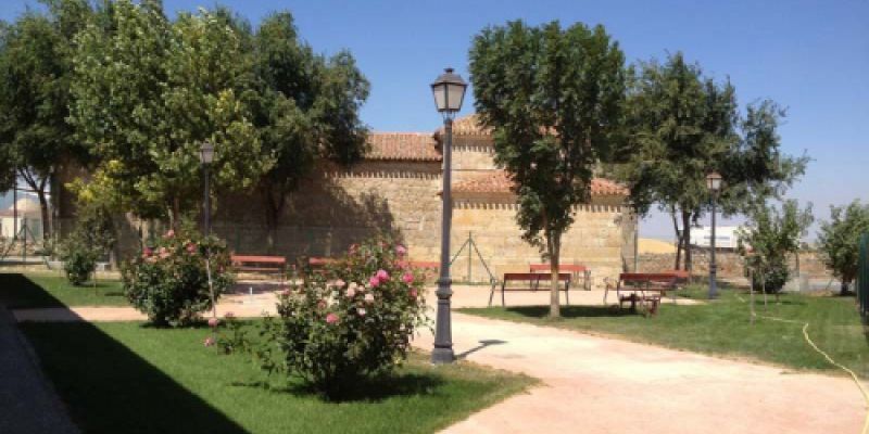 Zona de parque con sombra y bancos junto a la iglesia de Autilla