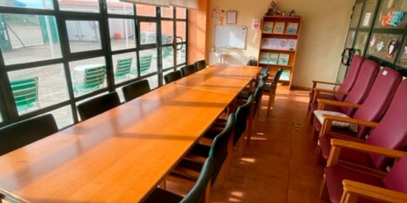 Sala de actividades para internos muy iluminada y con una mesa grande en el centro