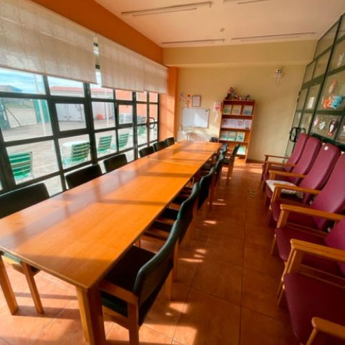 Sala de actividades para internos muy iluminada y con una mesa grande en el centro