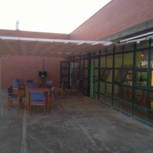 Terraza exterior del edificio con mesas para el uso de la de los residentes